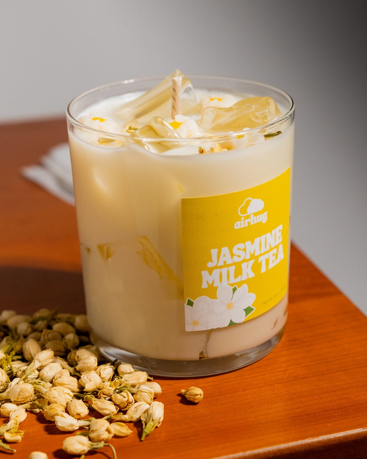 Glass of jasmine milk tea with a label on a wooden surface