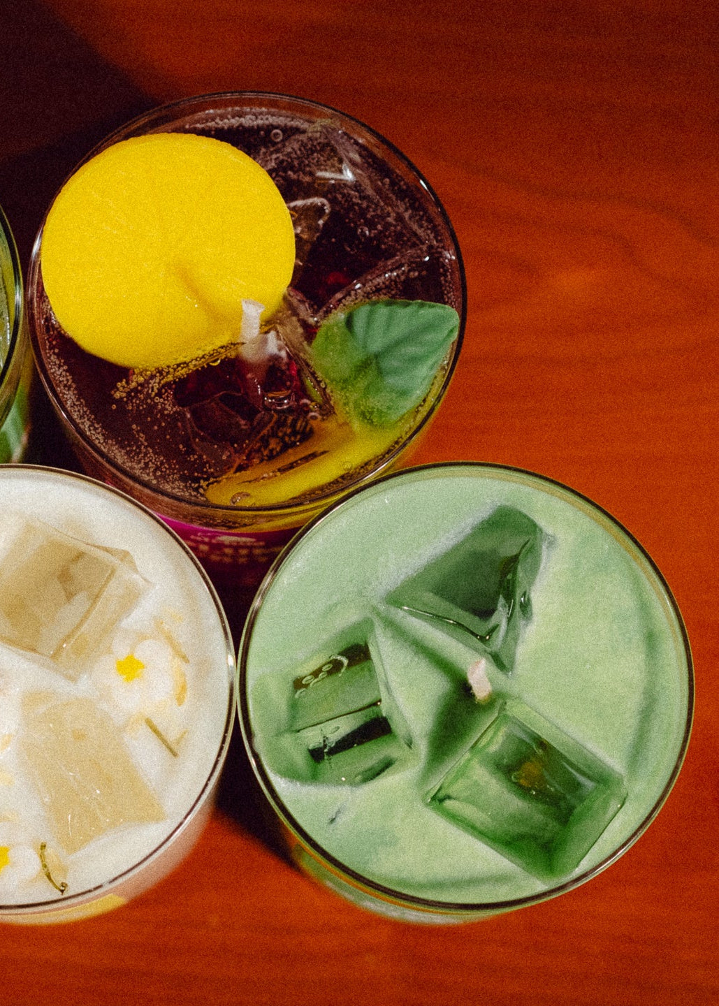 Three candles with different designs on a wooden surface
